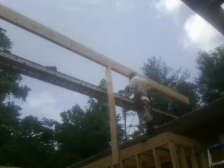 Carpenter setting a ridge beam over a new addition frame — Ice Dam Removal by Roofing Brothers in Mount Joy