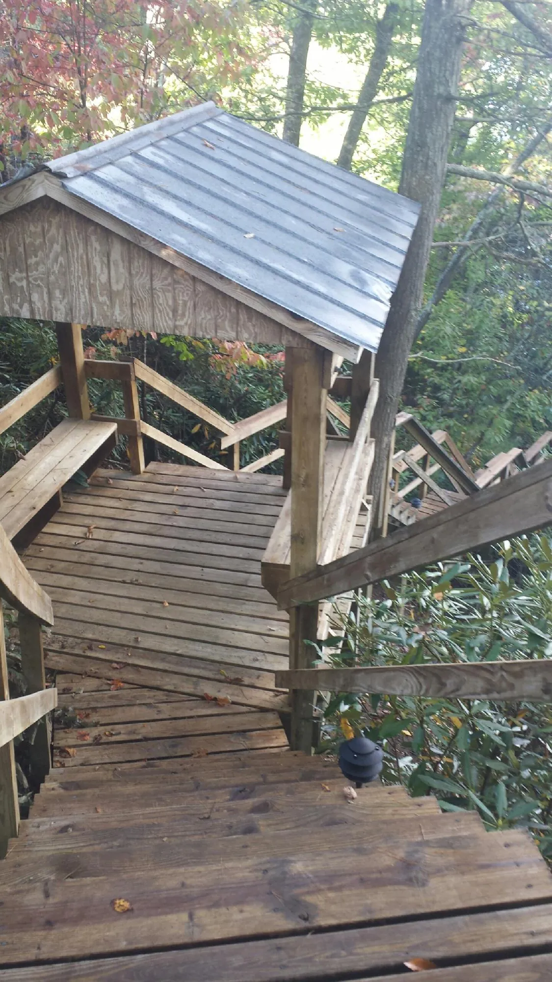 Metal roofed shelter over wooden steps on a wooded walkway — Skylight Repair & Installation work by our crew in Mount Joy