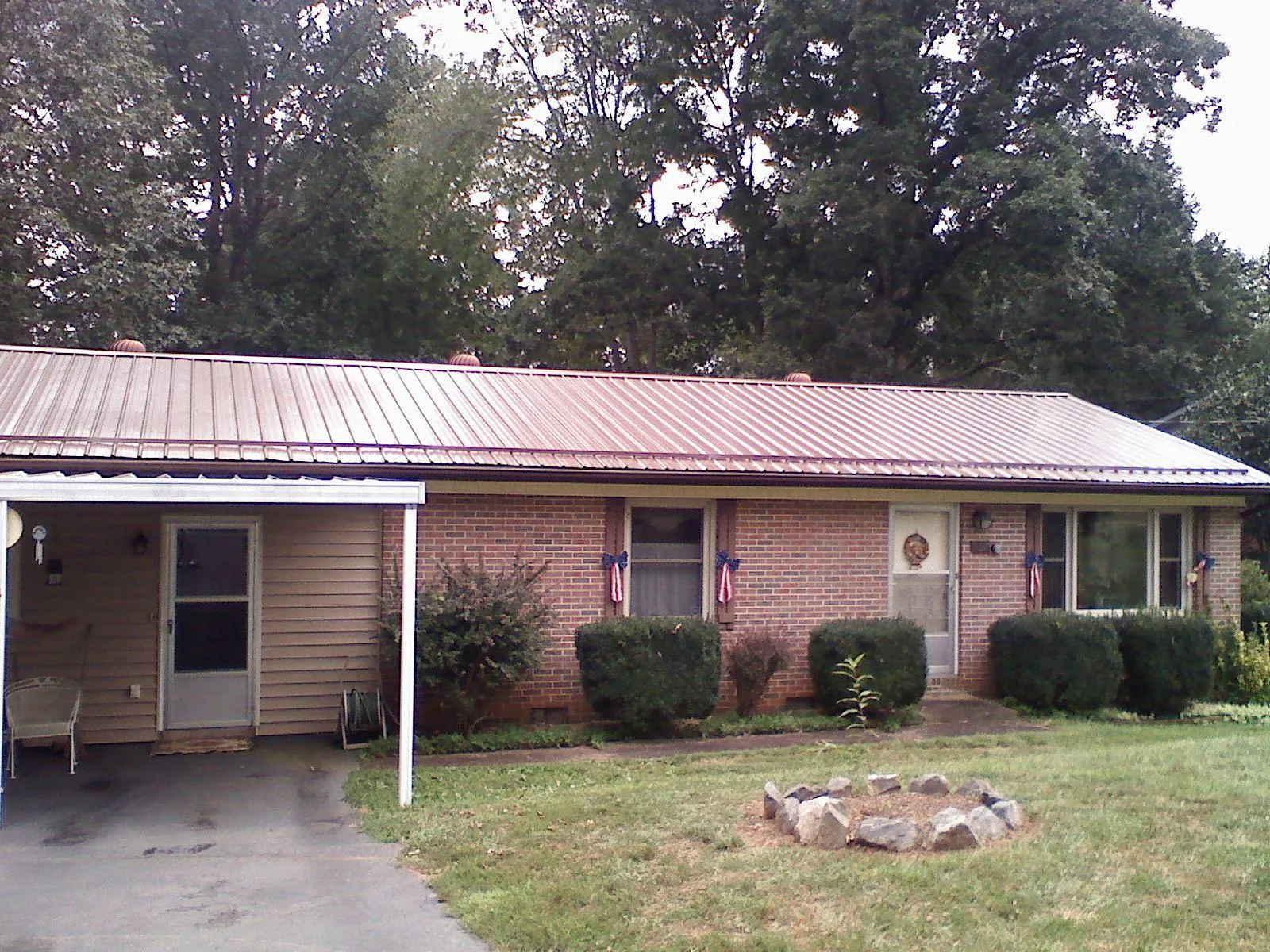Bronze metal roof and carport on a brick ranch home — Roof Repair work by our crew in Mount Joy